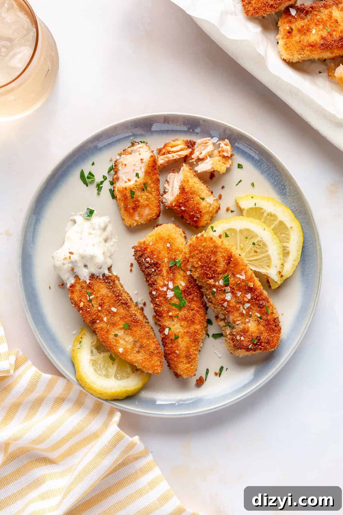 Easy Crispy Salmon Fish Sticks on plate with lemon slices and tartar sauce.