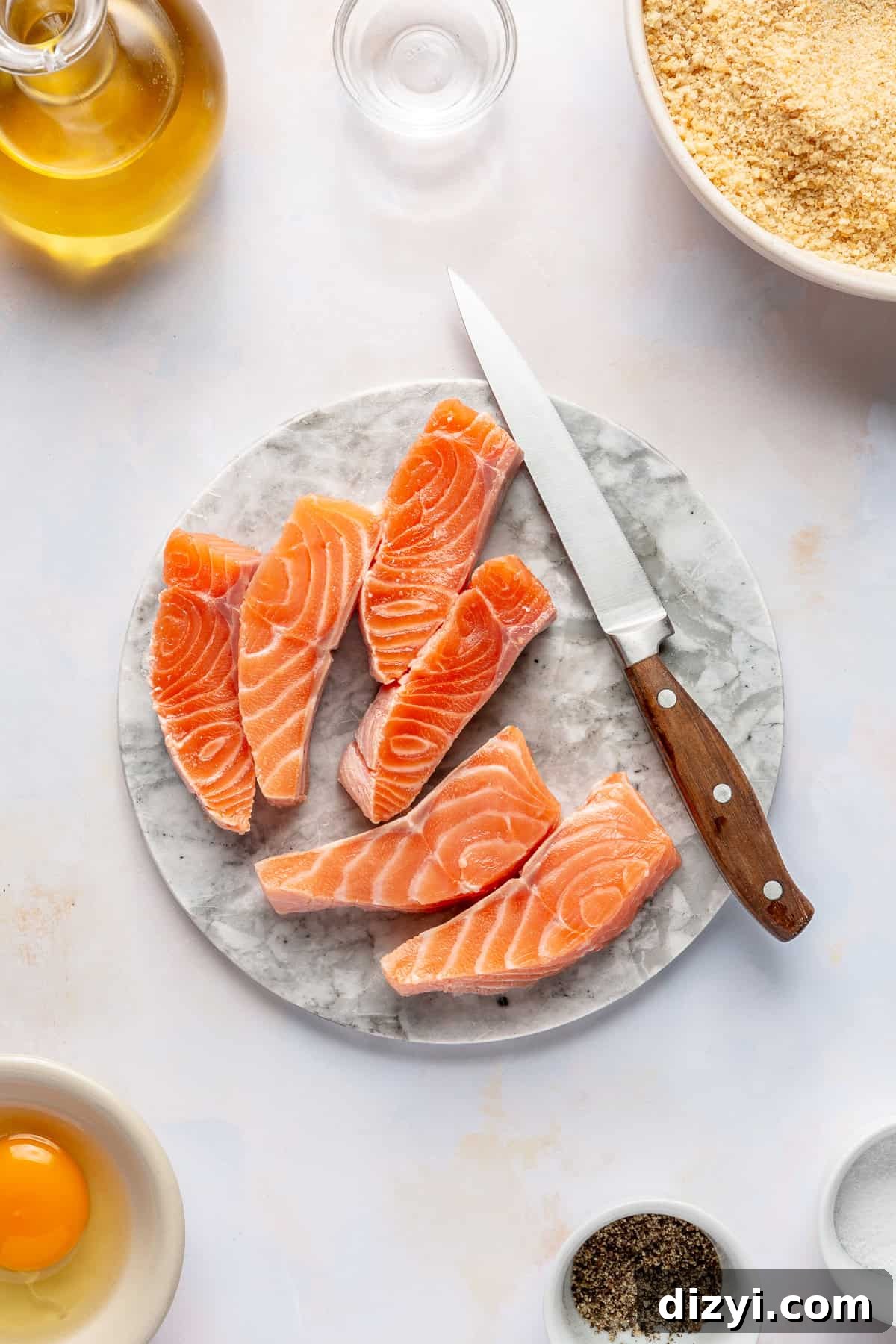 Salmon sliced into sticks on cutting board.