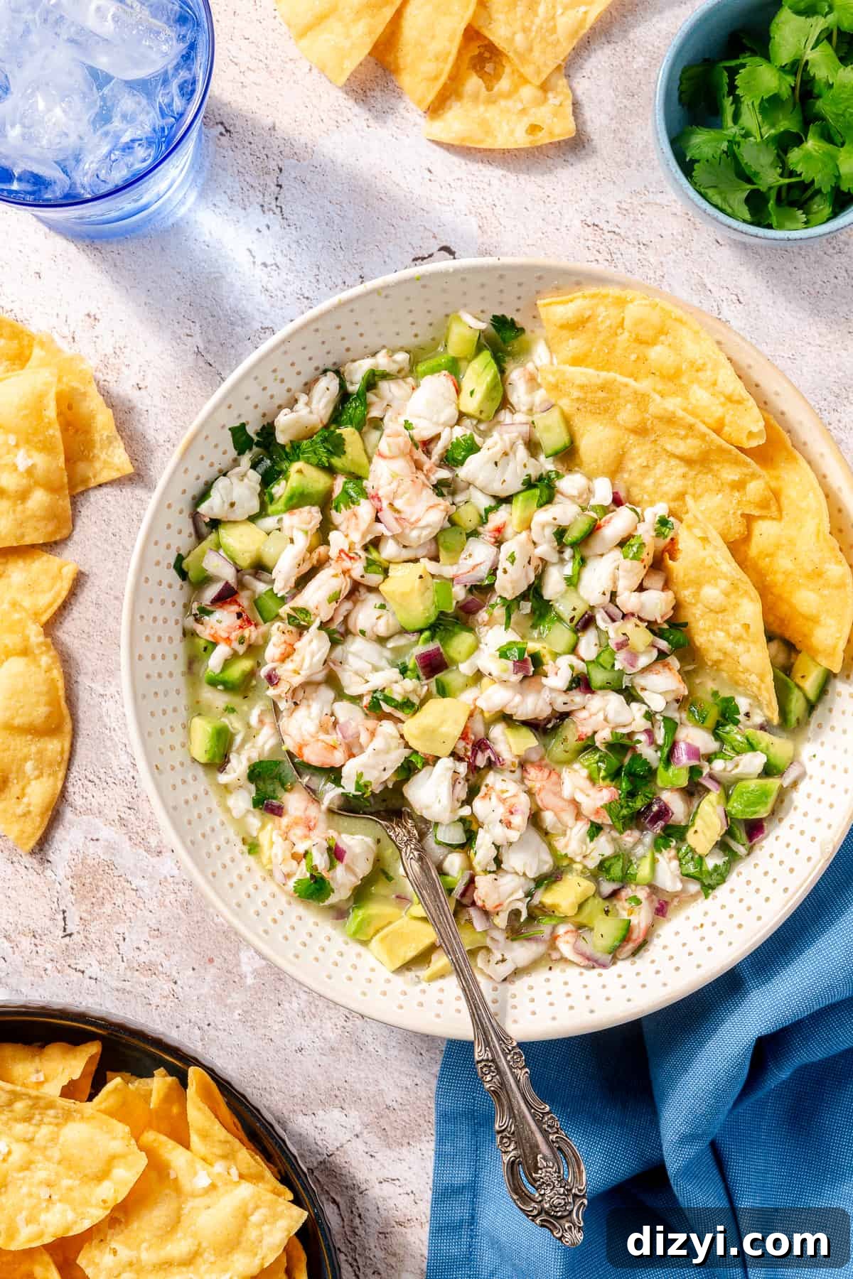 White dotted bowl filled with Shrimp Ceviche. Chips in the corner of the bowl.