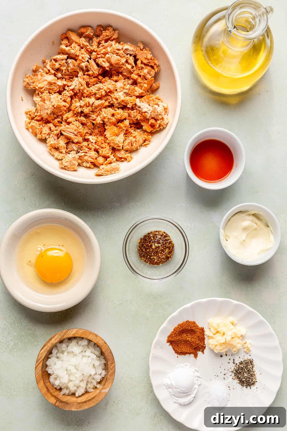 All the ingredients necessary to make Salmon Croquettes in various bowls on a white counter.