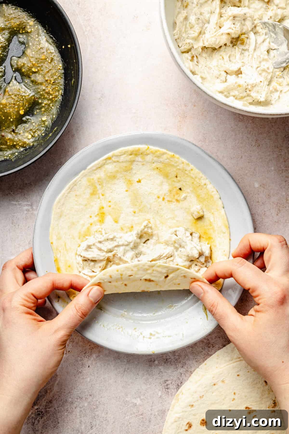 Creamy Green Chile Chicken Enchiladas 5 a home cook folding homemade chicken enchiladas