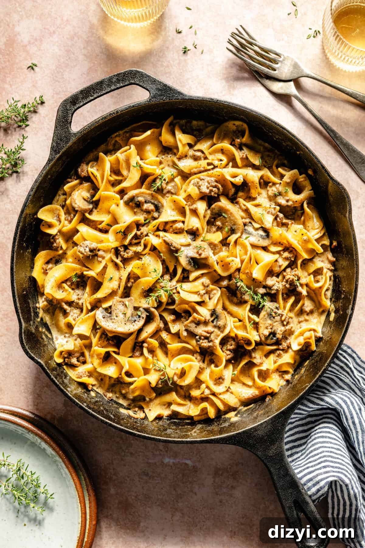 One-Pot Beef Stroganoff with Ground Beef 2 a cast-iron skillet with egg noodles, ground beef, mushrooms, and fresh thyme