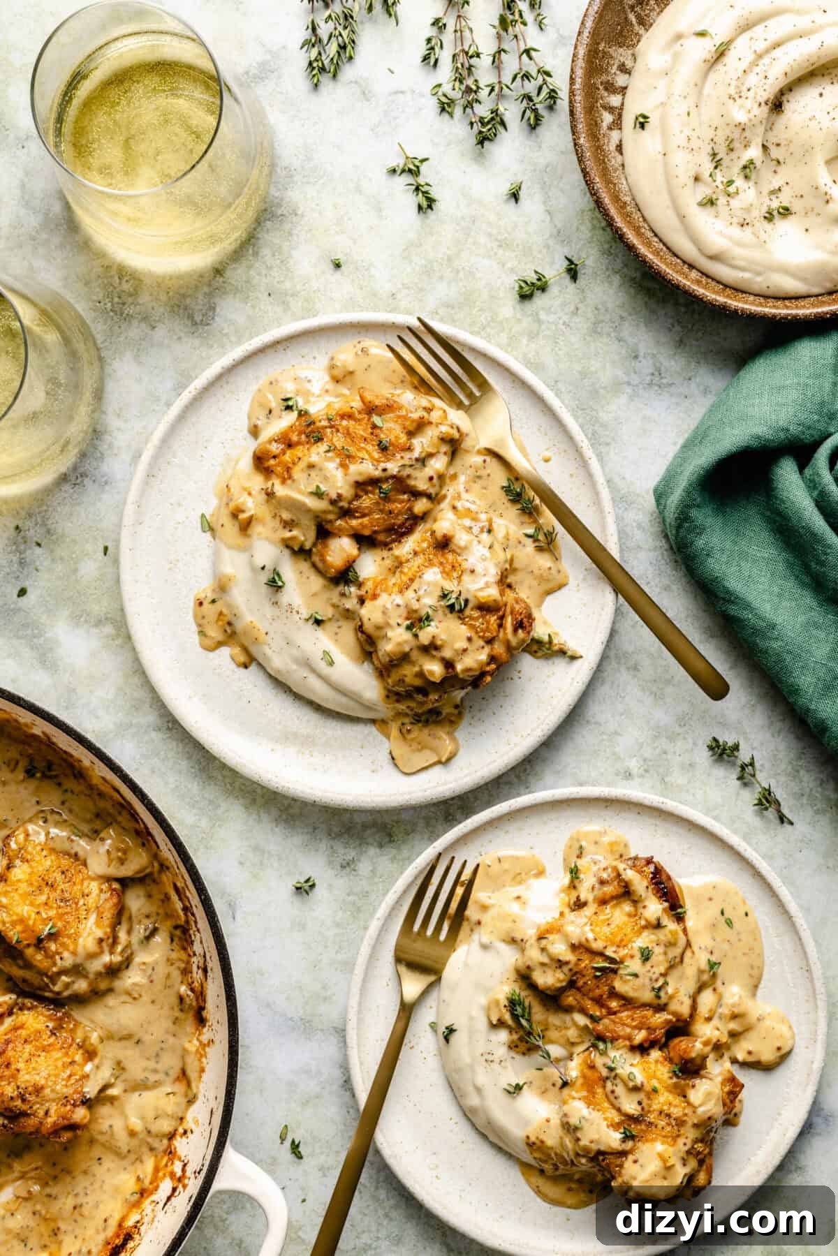 French Chicken with Creamy Mustard-White Wine Sauce plated with wine glasses surrounding.