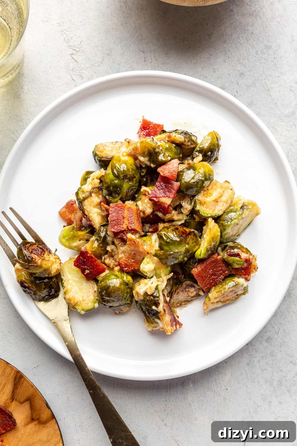 Scoop of Brussels Sprouts Au Gratin on white plate with fork.