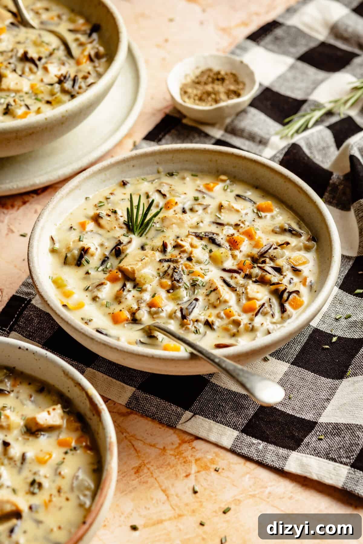 A finished bowl of Dairy Free Chicken and Wild Rice Soup on a black and white gingham placemat.