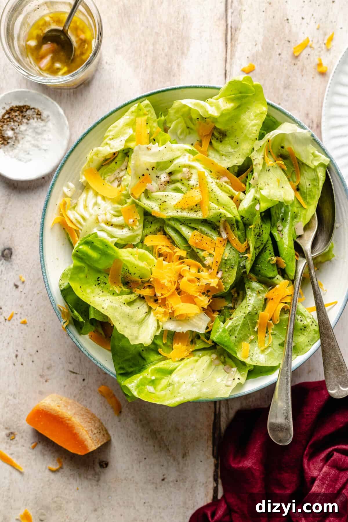 Bibb Lettuce Salad with Black Truffle Vinaigrette and Mimolette Recipe 2 Bibb Salad with Black Truffle Vinaigrette + Mimolette in serving bowl Cheese block and dressing in jar next to it.