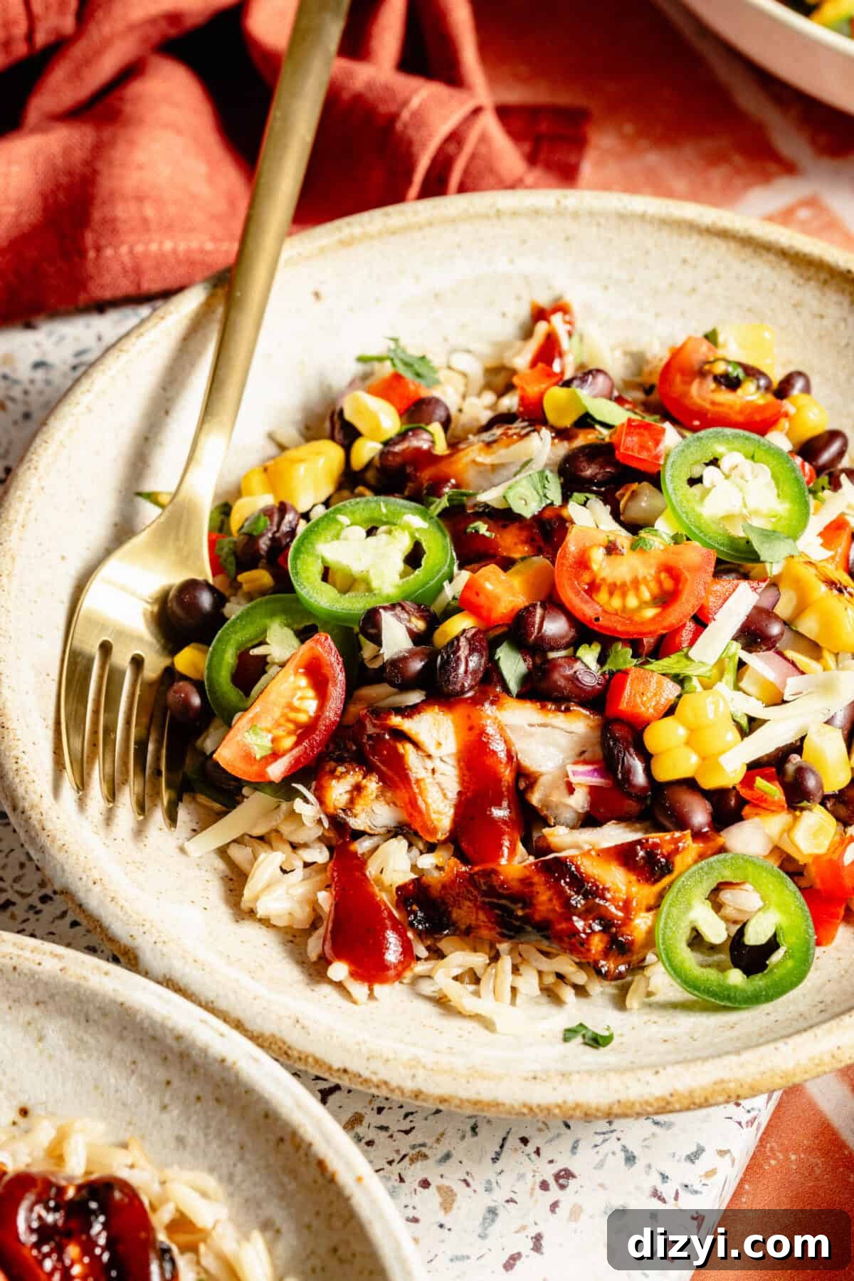 Father's Day Dinner Ideas Dad Will Love 8 Side view of Grilled BBQ Chicken Bowls with Black Bean-Corn Salad in a white bowl. Red napkin in background.
