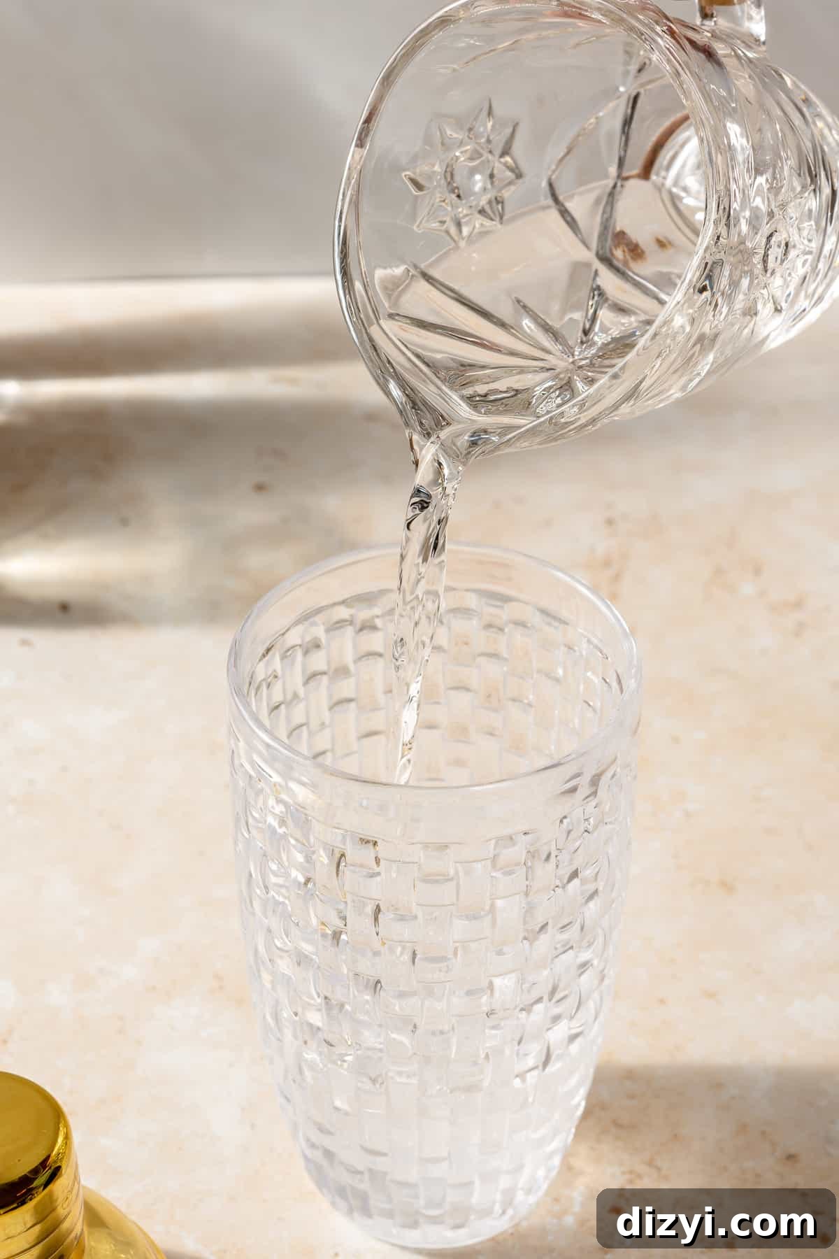 Vodka pouring into glass shaker.