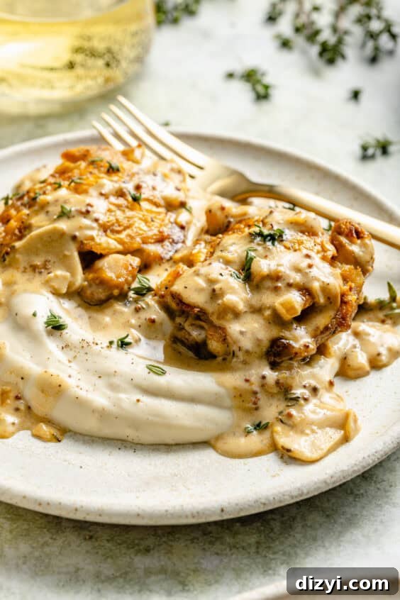 French Chicken with Creamy Mustard-White Wine Sauce on a plate with mash.