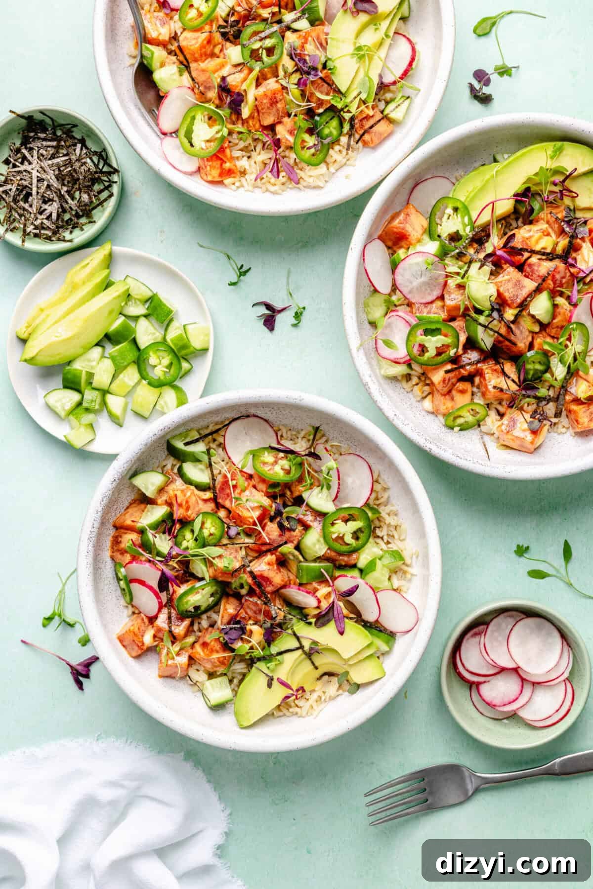 Spicy Hawaiian Ahi Poke Bowl Recipe 2 Hawaiian-Inspired Spicy Tuna Poke in bowls on blue surface.
