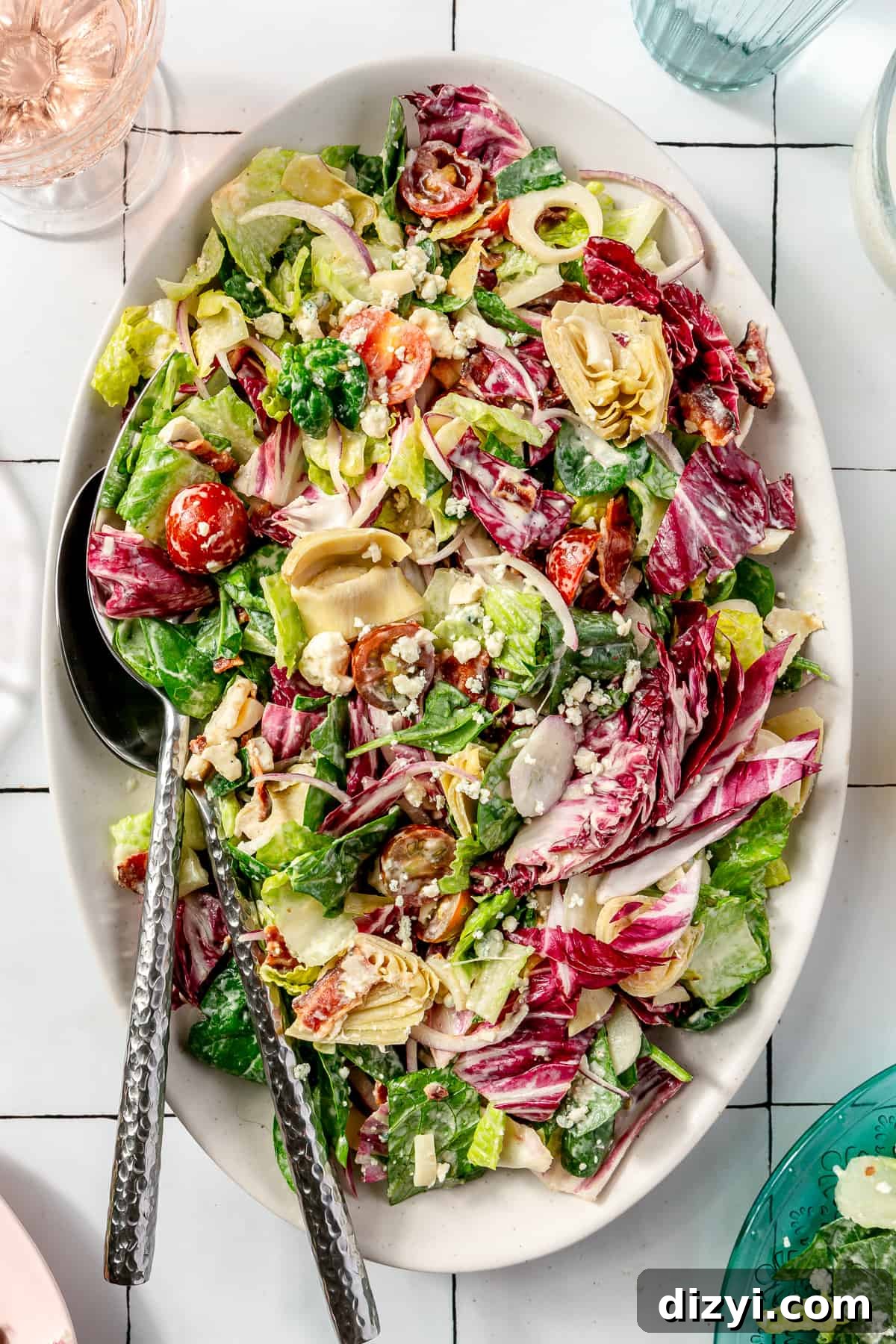 Steakhouse Chopped Salad on a large oval platter. Stack of plate peeking in.
