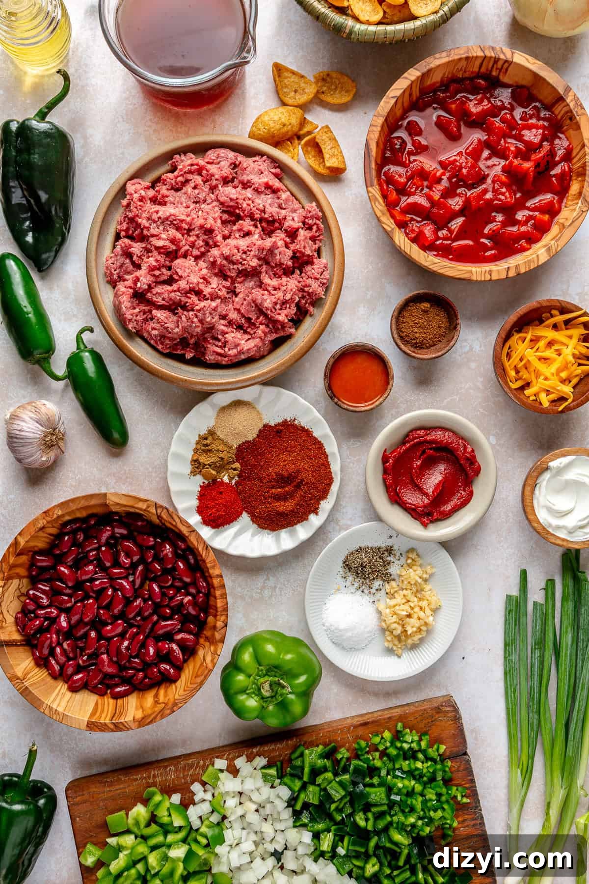 All the ingredients necessary to make Beef Chili with Beans spread over a white table.