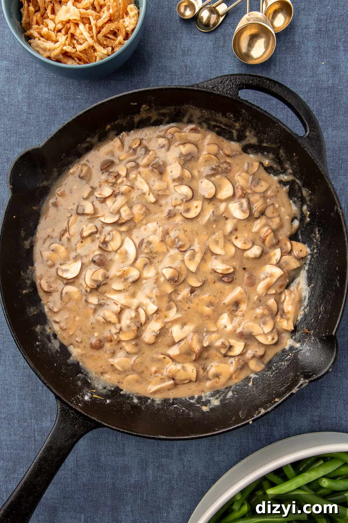 Mushrooms and roux ingredients in black skillet sautéing for Homemade Green Bean Casserole sauce