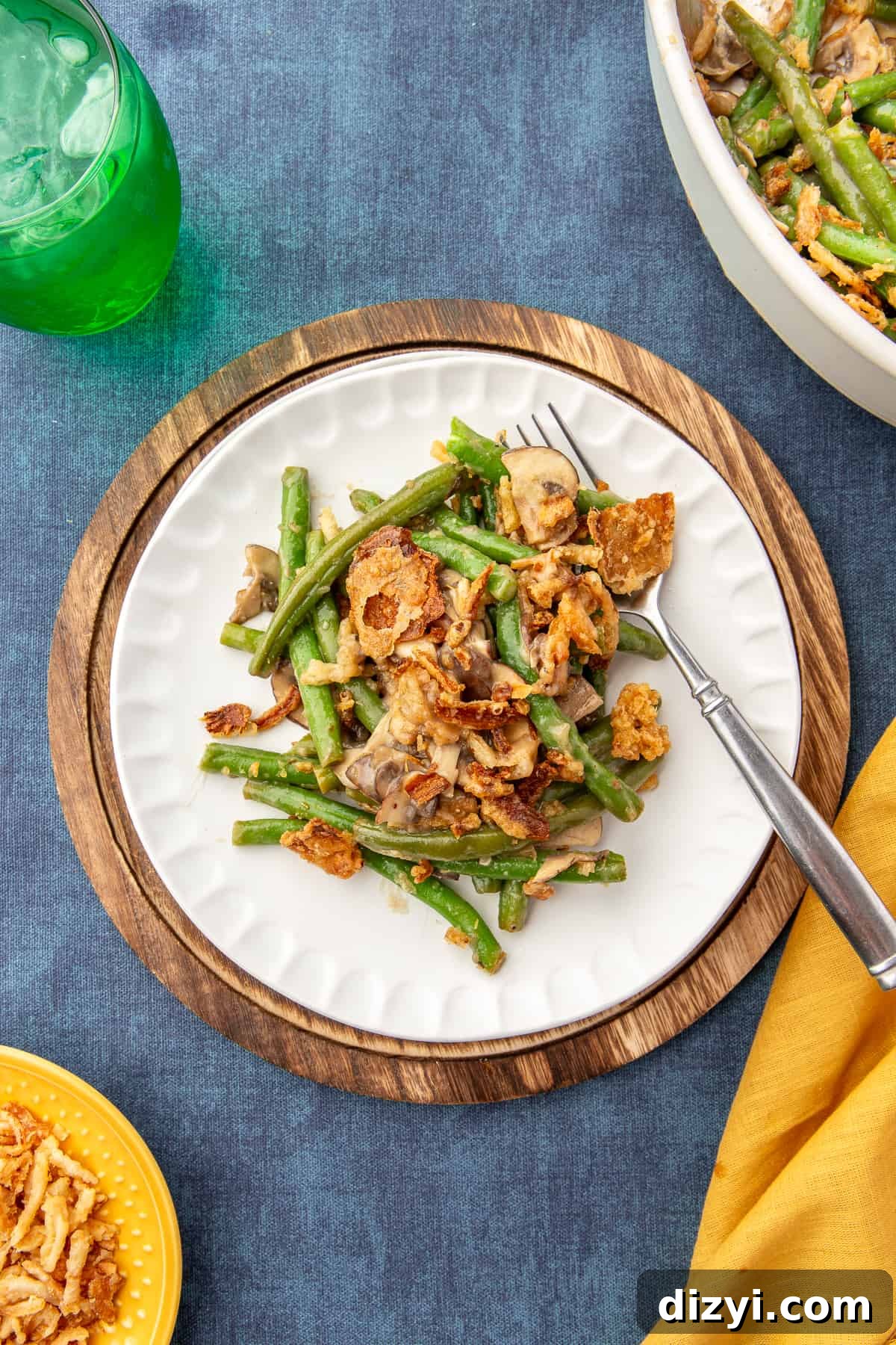 Scoop of Homemade Green Bean Casserole on a small white plate with fork in it