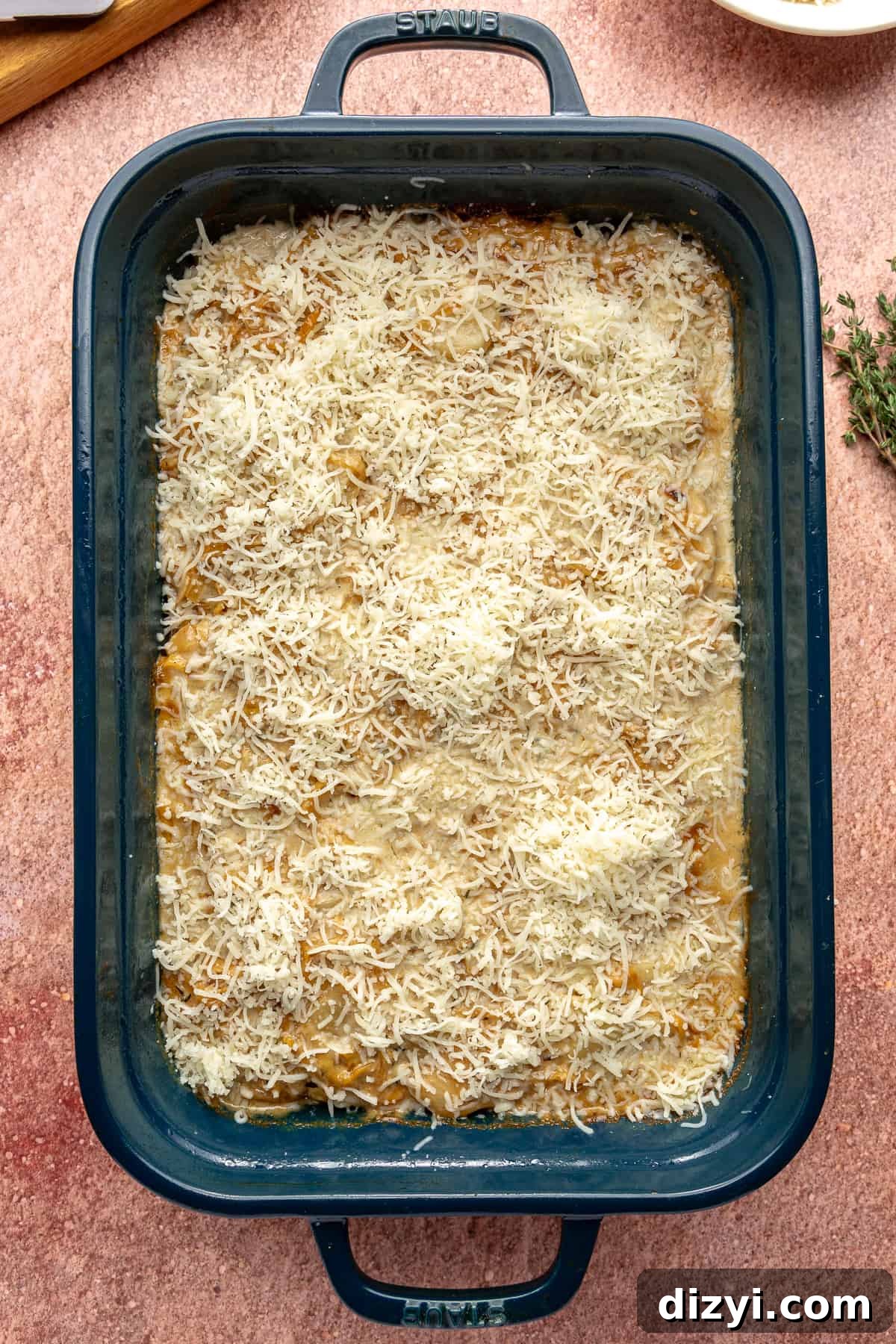 Creamy Scalloped Potatoes with Caramelized Onions 9 Uncooked Caramelized Onion Scalloped Potatoes in a blue baking dish.