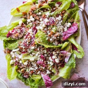 Salad greens piled on a large platter with bacon, shallots, and dressing piled on top.