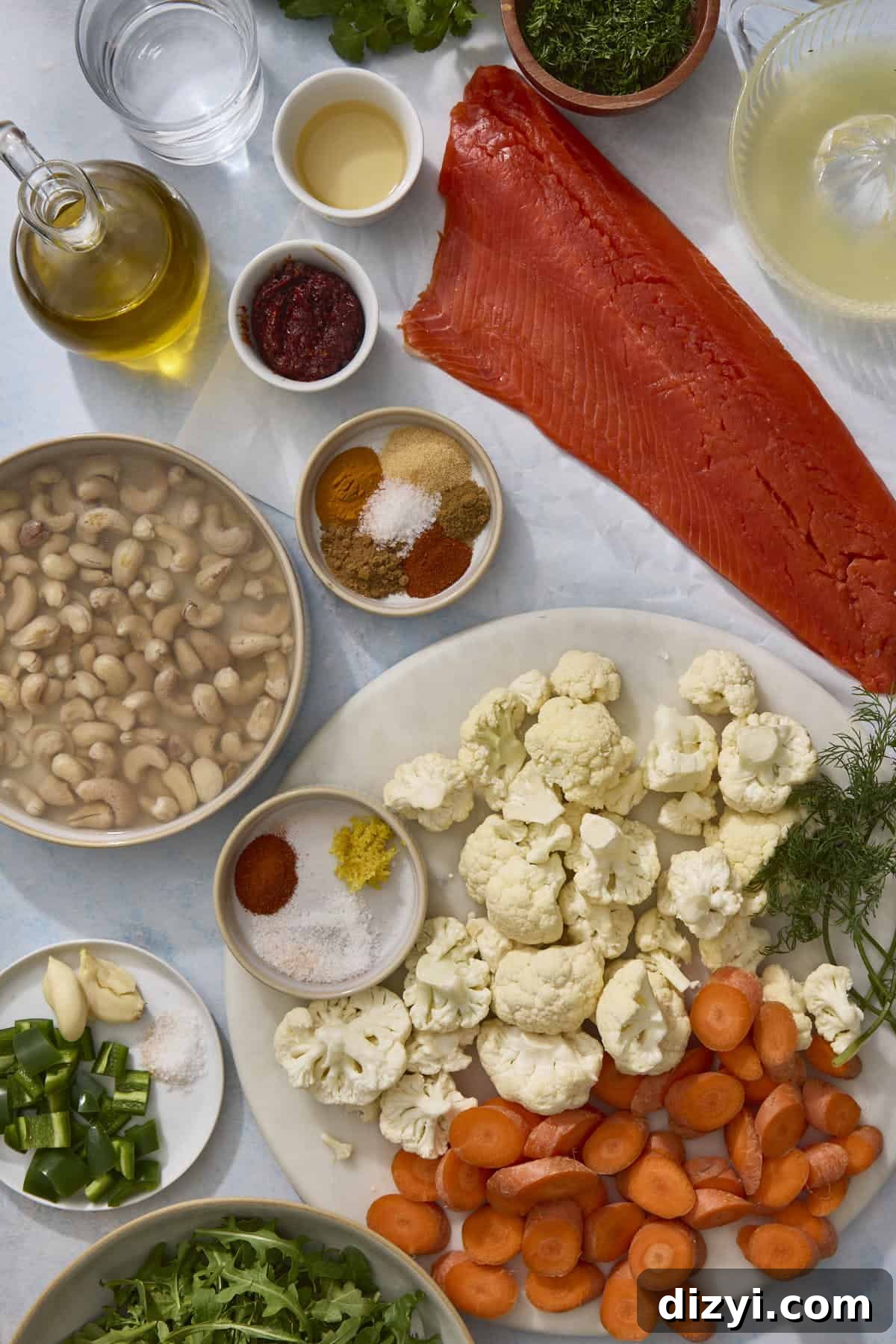 Sheet Pan Harissa Salmon + Roasted Veggies with Cashew Crema ingredients laid on counter.