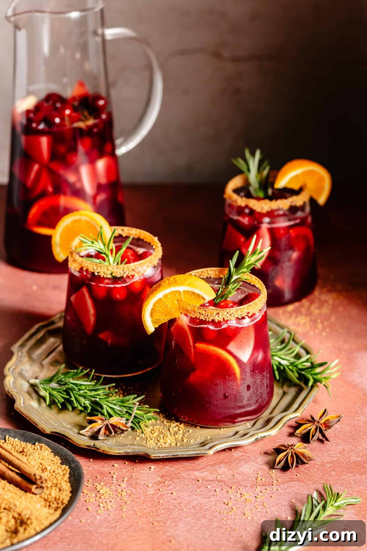 Holiday Sangria in a pitcher plus served in three stemless glasses.