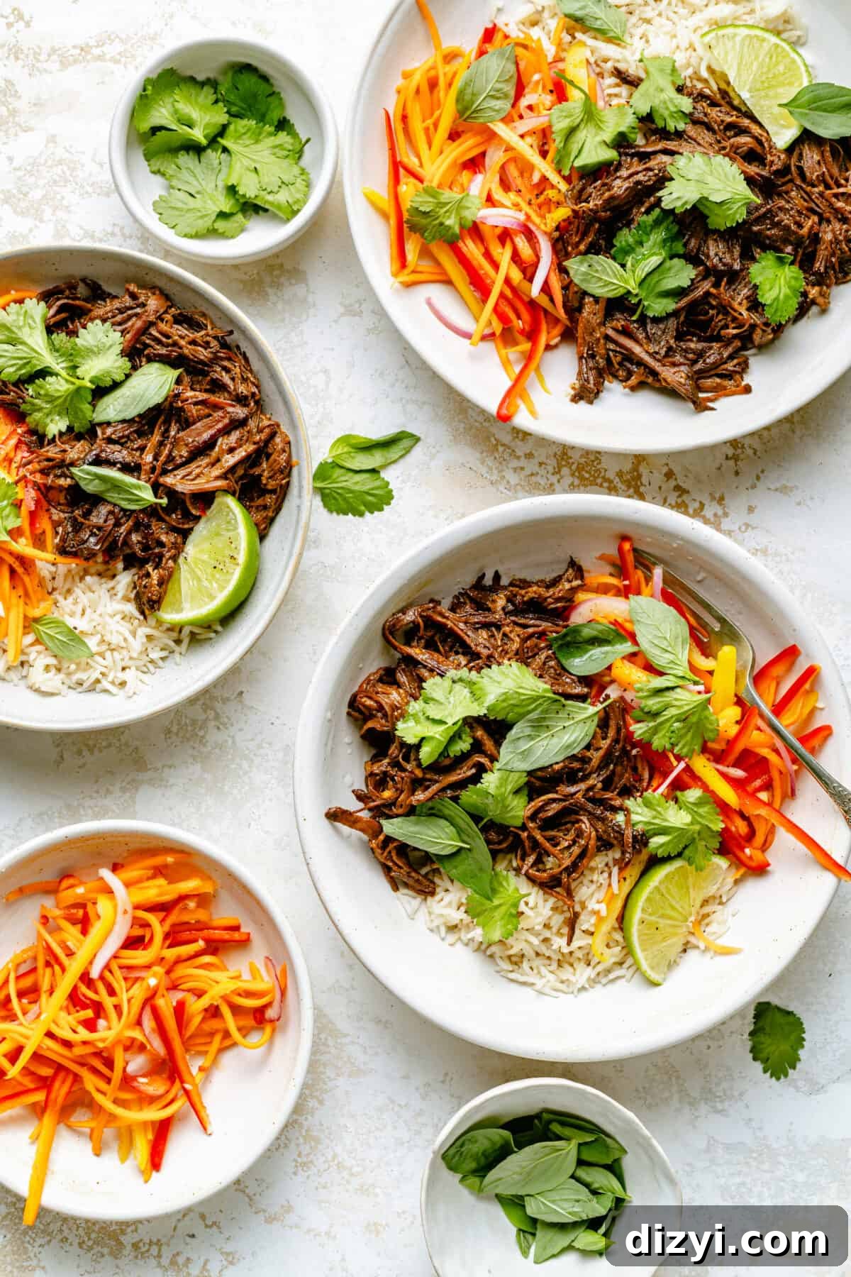 Slow Cooker Thai-Style Beef Bowls Recipe 2 Three bowls with beef, rice, and veggie slaw, topped with herbs on a white stone backdrop.