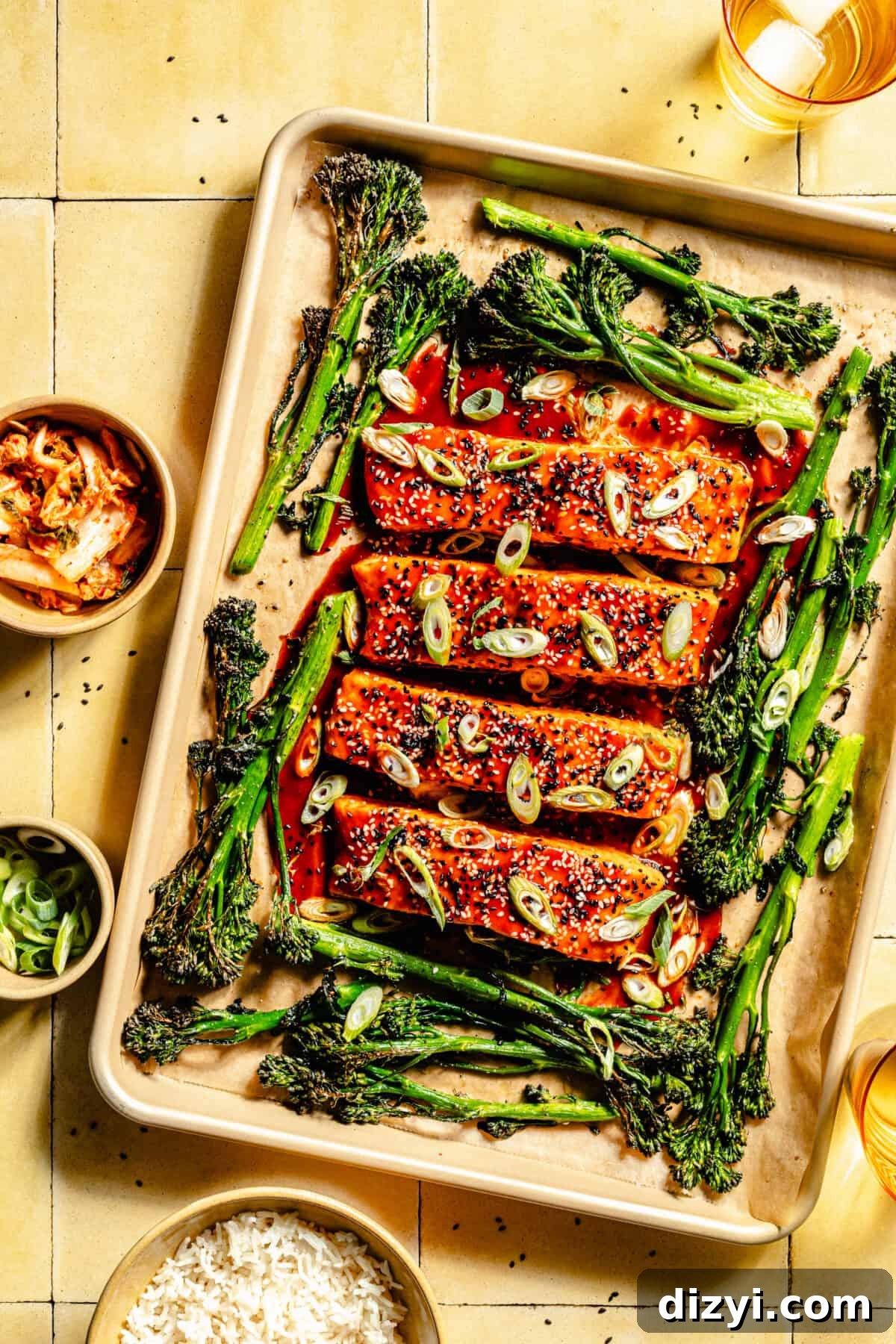 Gochujang-Glazed Sheet Pan Salmon 2 Gochujang Glazed Salmon and broccolini on a sheet pan. Small bowls of rice, kimchi, and green onion next to sheet pan.