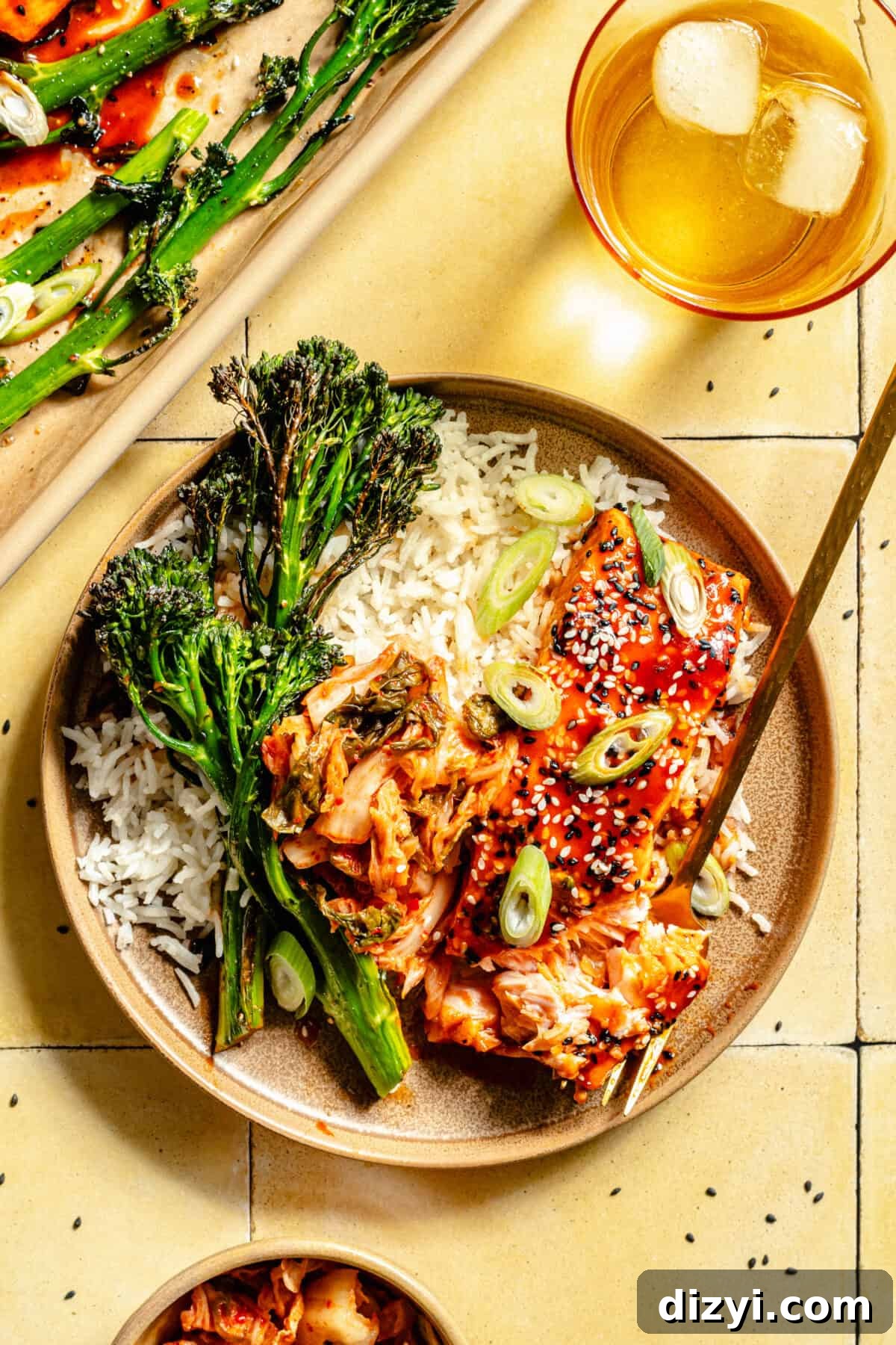 Gochujang-Glazed Sheet Pan Salmon 3 Overhead shot of Gochujang Glazed Salmon on a plate with broccolini. Fork is placed into salmon.