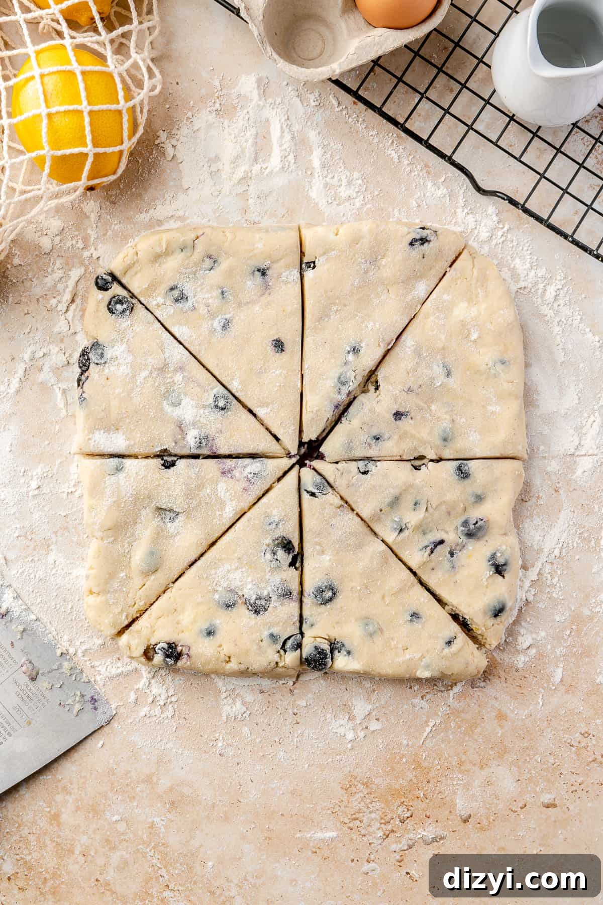 Scone dough cut into 8 triangles on floured surface.