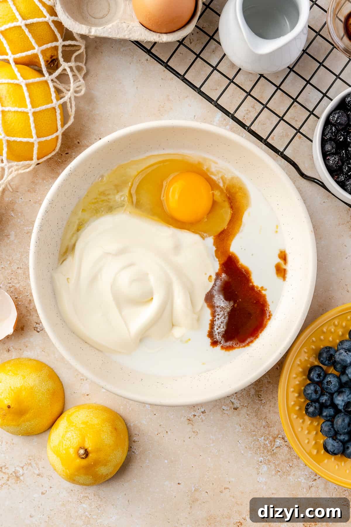 Egg, vanilla extract, and greek yogurt in bowl with  the lemon zest, sugar, and buttermilk. Not stirred.