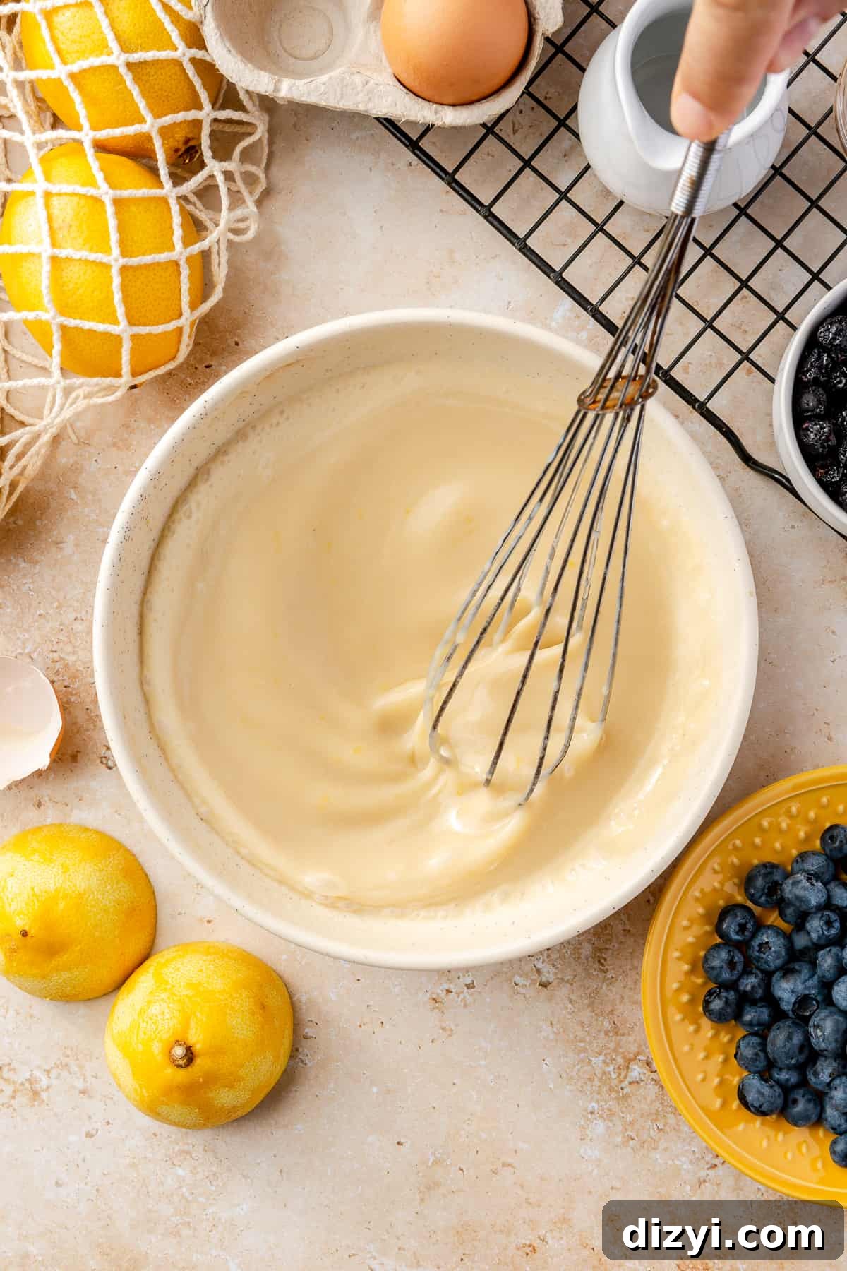 Egg, vanilla extract, and greek yogurt in bowl with the lemon zest, sugar, and buttermilk. Whisked to combine with whisk in bowl.