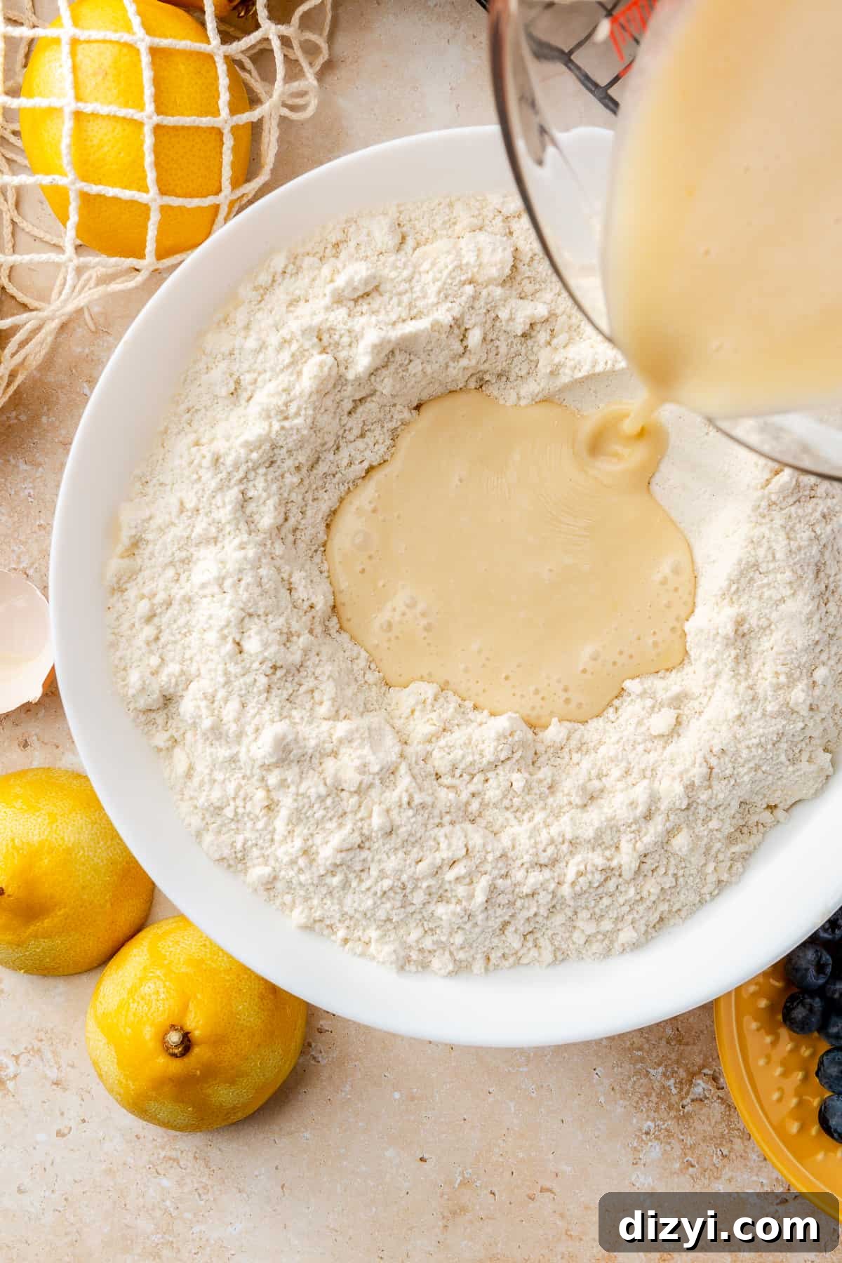 Bowl of dry ingredients and butter with wet ingredients poured in the center.