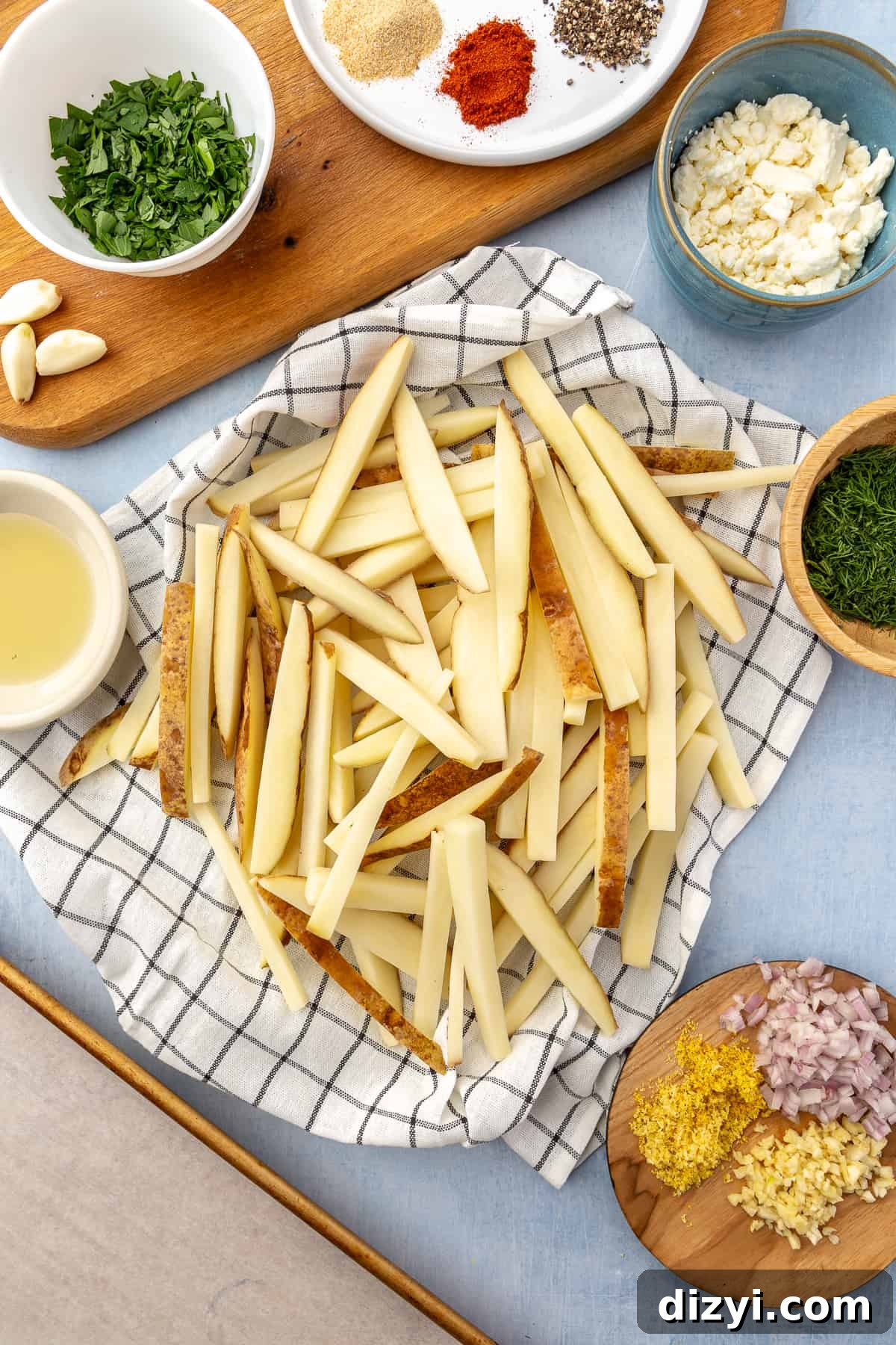 Crispy Greek Feta Fries with Romesco Ranch Dip 3 Ingredients for Greek-inspired Feta Fries with Romesco Ranch layed out on light blue background.