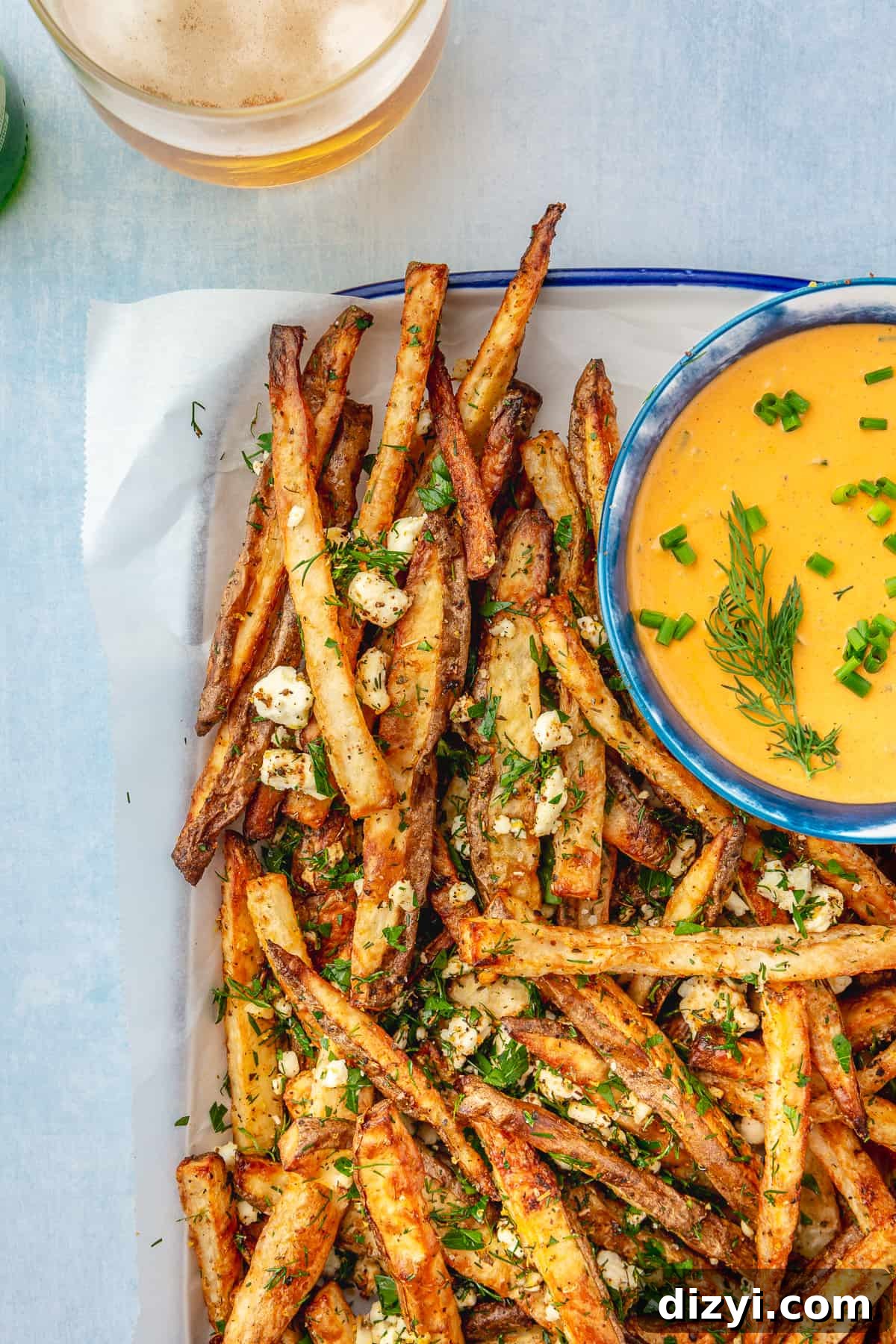 Crispy Greek Feta Fries with Romesco Ranch Dip 10 Platter lined with parchment paper filled with Greek-inspired Feta Fries with side bowl of Romesco Ranch.