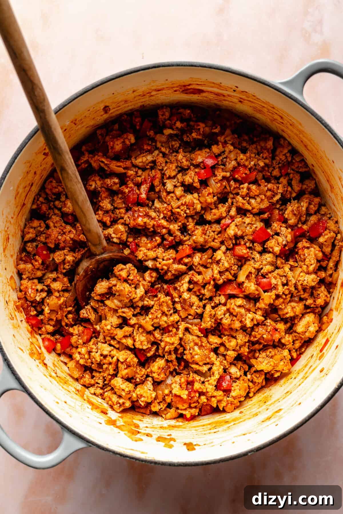 Cheesy Chicken Enchilada Chili Recipe 4 Ground chicken browned in large dutch oven. Spoon sticking in it.