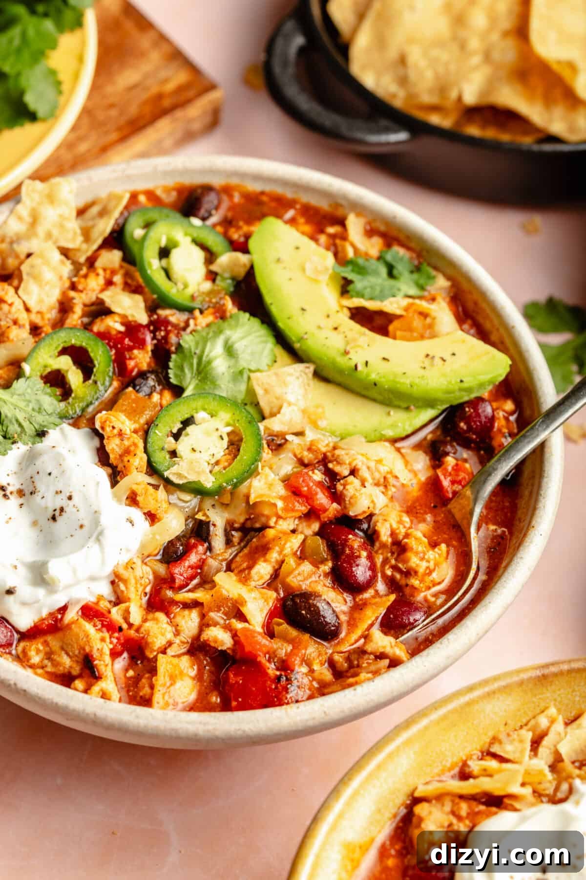 Cheesy Chicken Enchilada Chili Recipe 6 Bowl of Chicken Enchilada Chili garnished with cheese, avocado, sour cream and jalepenos.