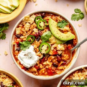 Cheesy Chicken Enchilada Chili Recipe 7 Three bowls of Chicken Enchilada Chili with garnishes surrounding.