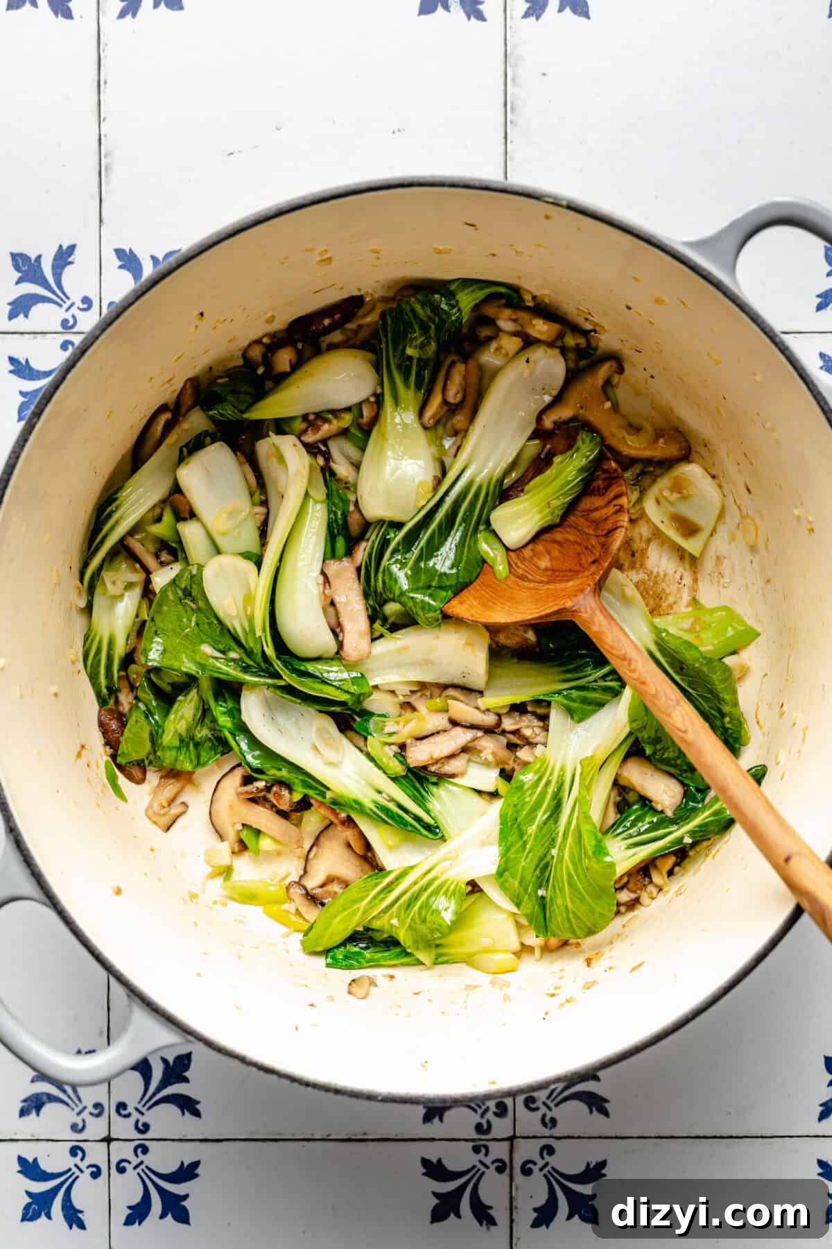 Baby bok choy, mushrooms and other veggies sautéing in Dutch oven.