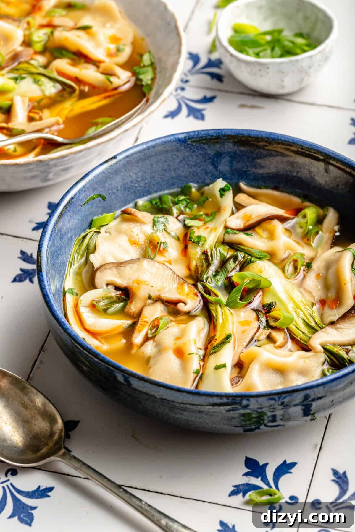 Blue bowl of 20-Minute Wonton Soup. White bowl of soup peeking in the back.