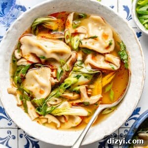 White bowl filled with 20-Minute Wonton Soup. Spoon resting in the bowl.