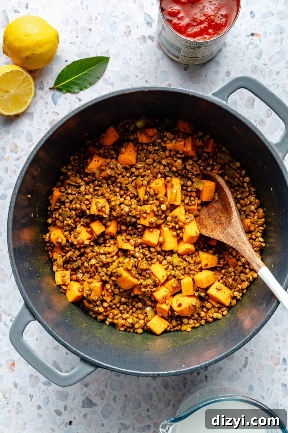 Veggies and lentils toasting in large dutch oven. Spoon resting in pot.