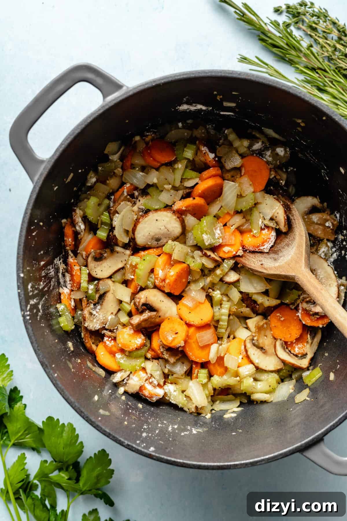 Classic Chicken Stew Recipe with Tender Vegetables 5 Large pot of carrots, mushrooms, and celery sautéing in dutch oven.
