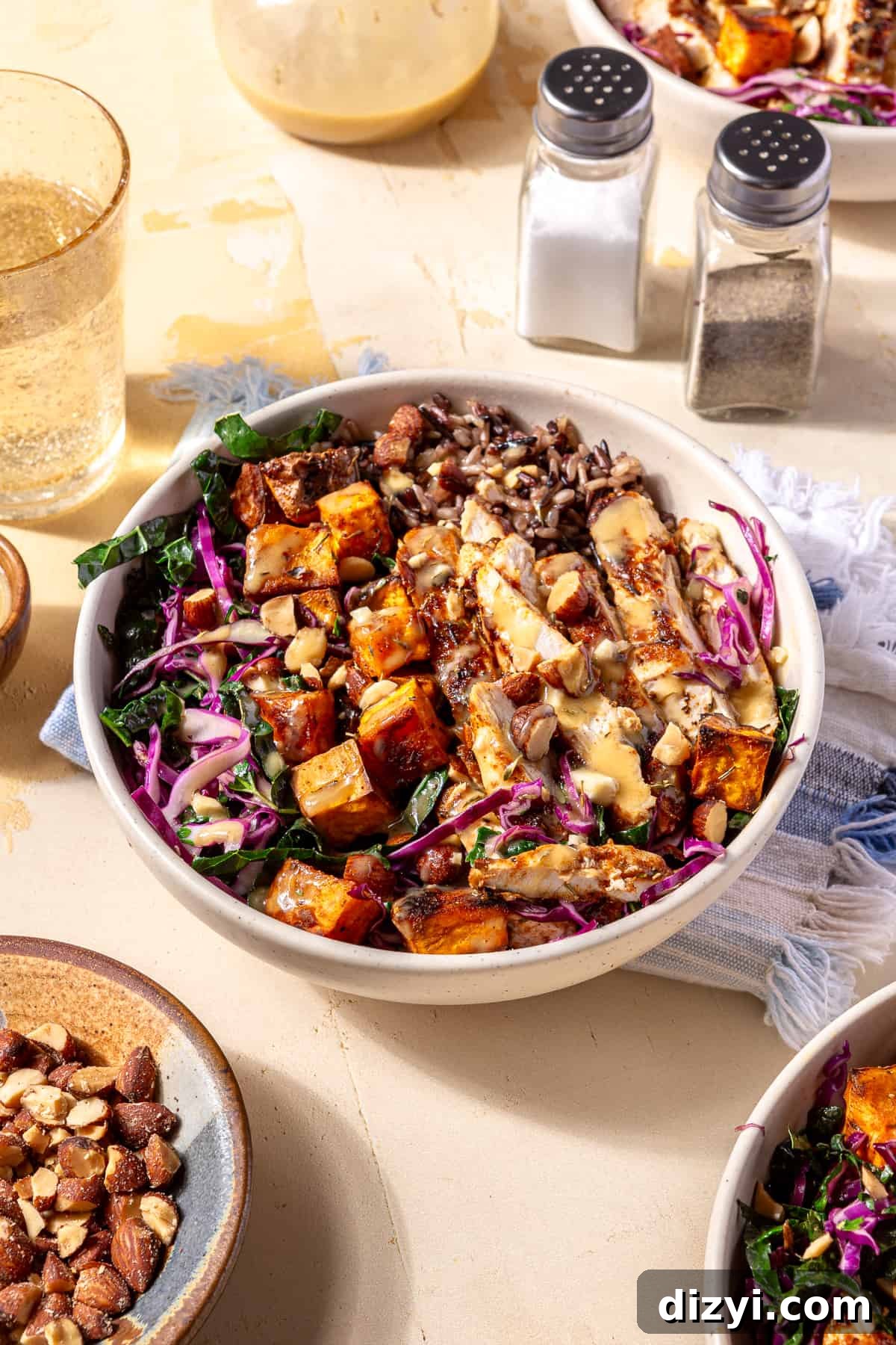 Sweetgreen Copycat Blackened Chicken and Sweet Potato Bowls 2 White bowl filled with Blackened Chicken and Sweet Potato with salt and pepper shaker behind it and other plates and glassware.