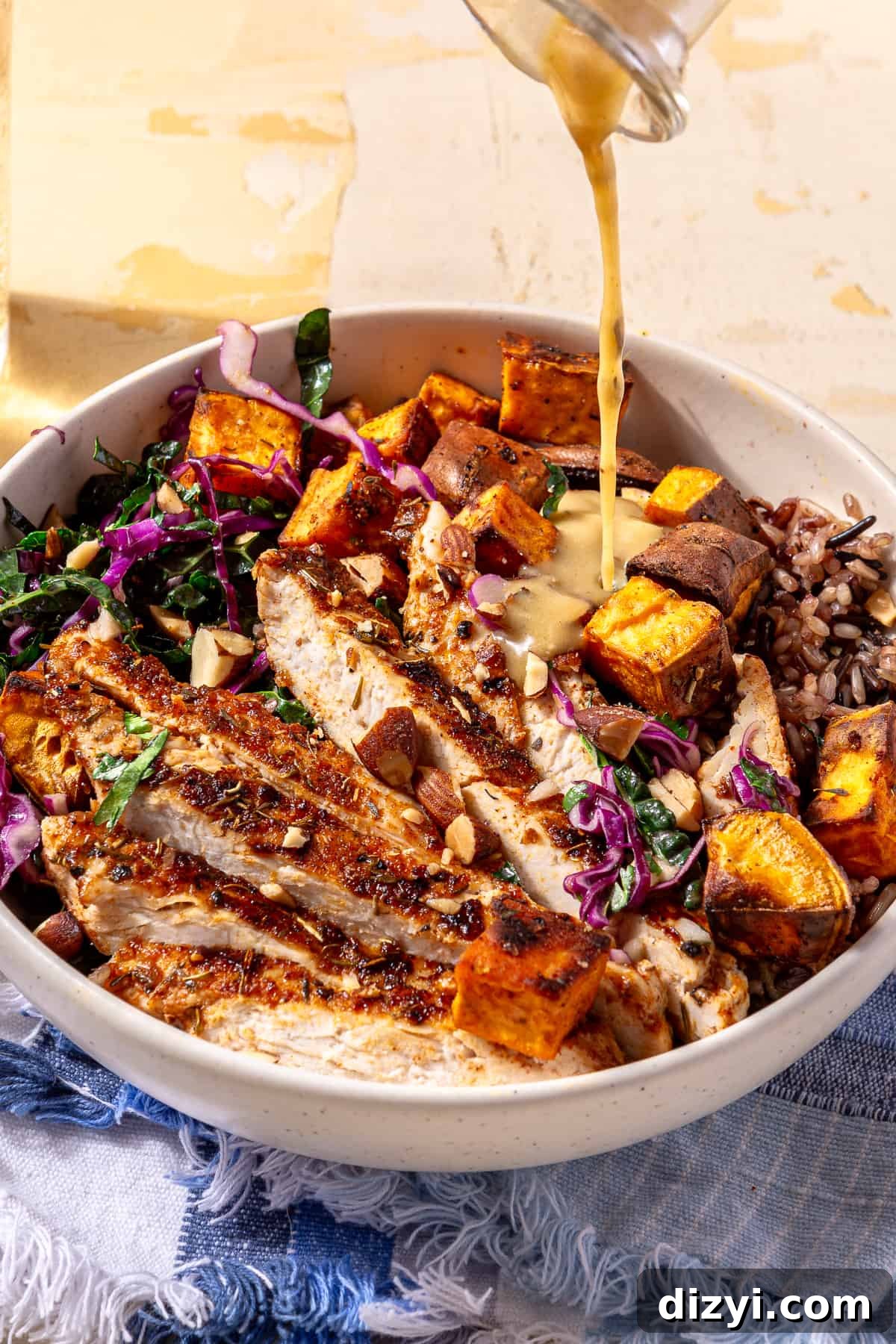 Sweetgreen Copycat Blackened Chicken and Sweet Potato Bowls 11 Blackened Chicken and Sweet Potato Bowl with dressing being drizzled over it.