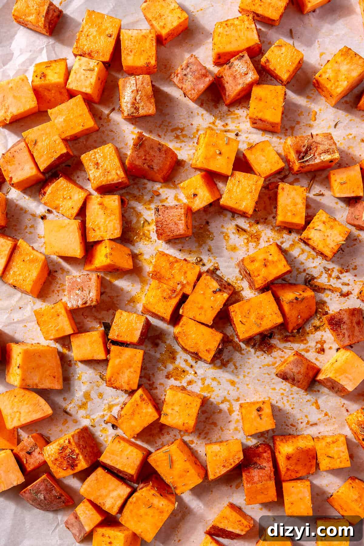 Sweetgreen Copycat Blackened Chicken and Sweet Potato Bowls 6 Diced sweet potatoes on a baking sheet with seasoning on top.