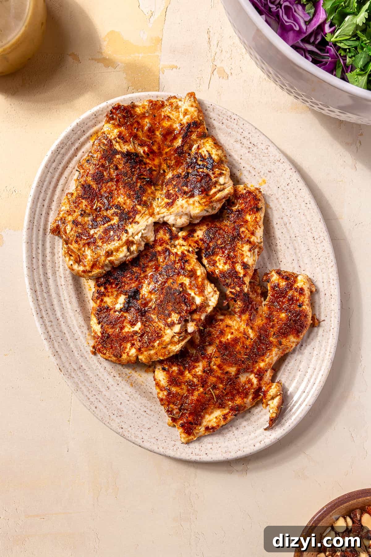 Sweetgreen Copycat Blackened Chicken and Sweet Potato Bowls 10 Three seared chicken breasts on a white, oval plate.