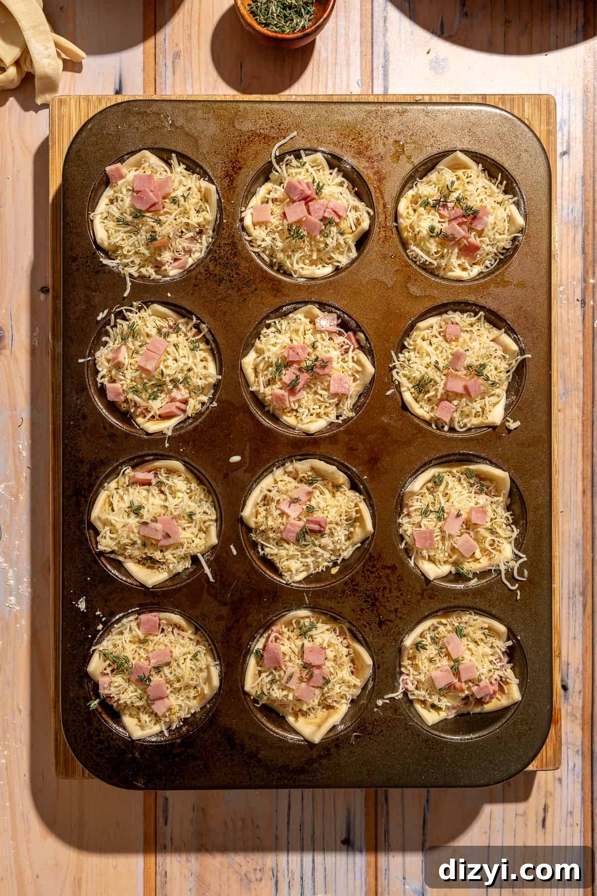 Raw Mini Croque Monsieur Bites in muffin tins.