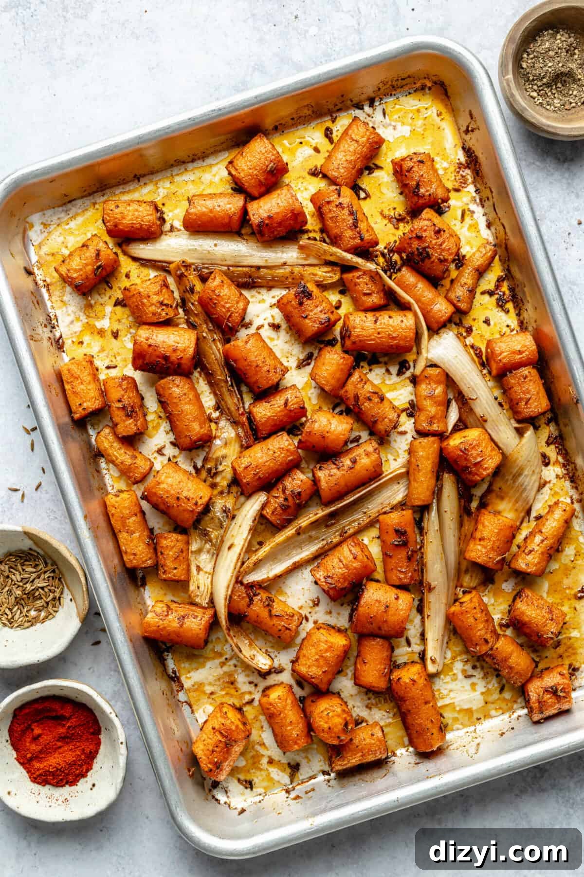 Roasted carrots and shallot on silver sheet pan.