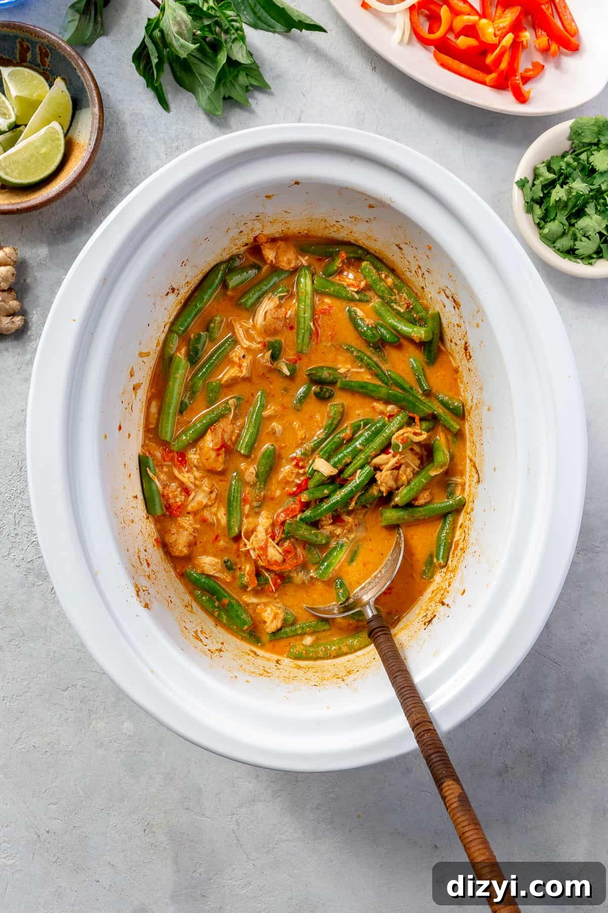 Slow Cooker Thai Red Curry with Chicken and Vegetables 6 Slow cooked filled with Slow Cooker Thai Red Curry Chicken and Veggies. Green bean pieces being stirred in.
