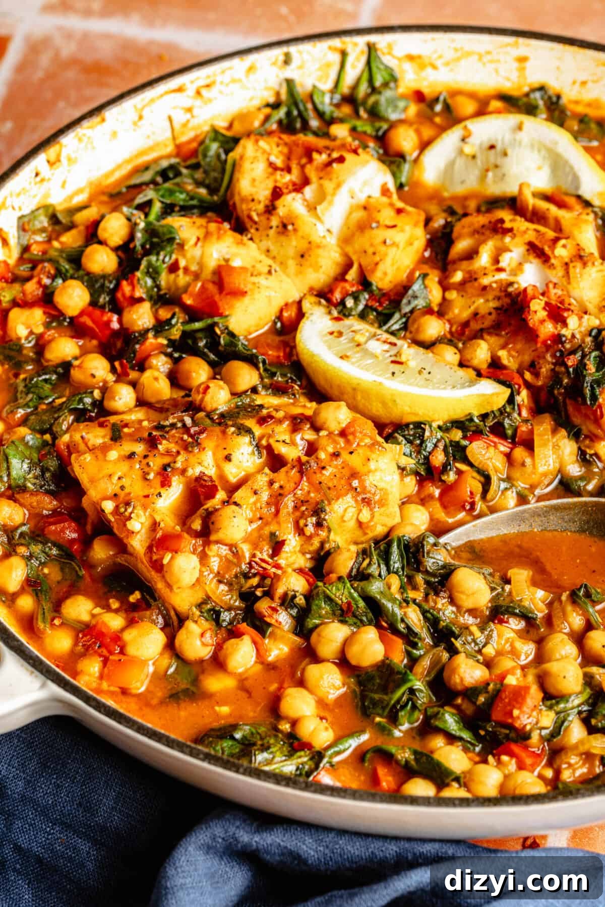 Close up of Spanish-Inspired Simmered White Fish on a skillet.