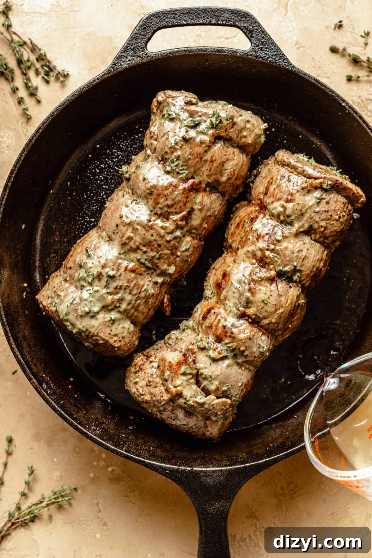 Beef Tenderloin browned and in skillet. Herb mixture brushed on top.
