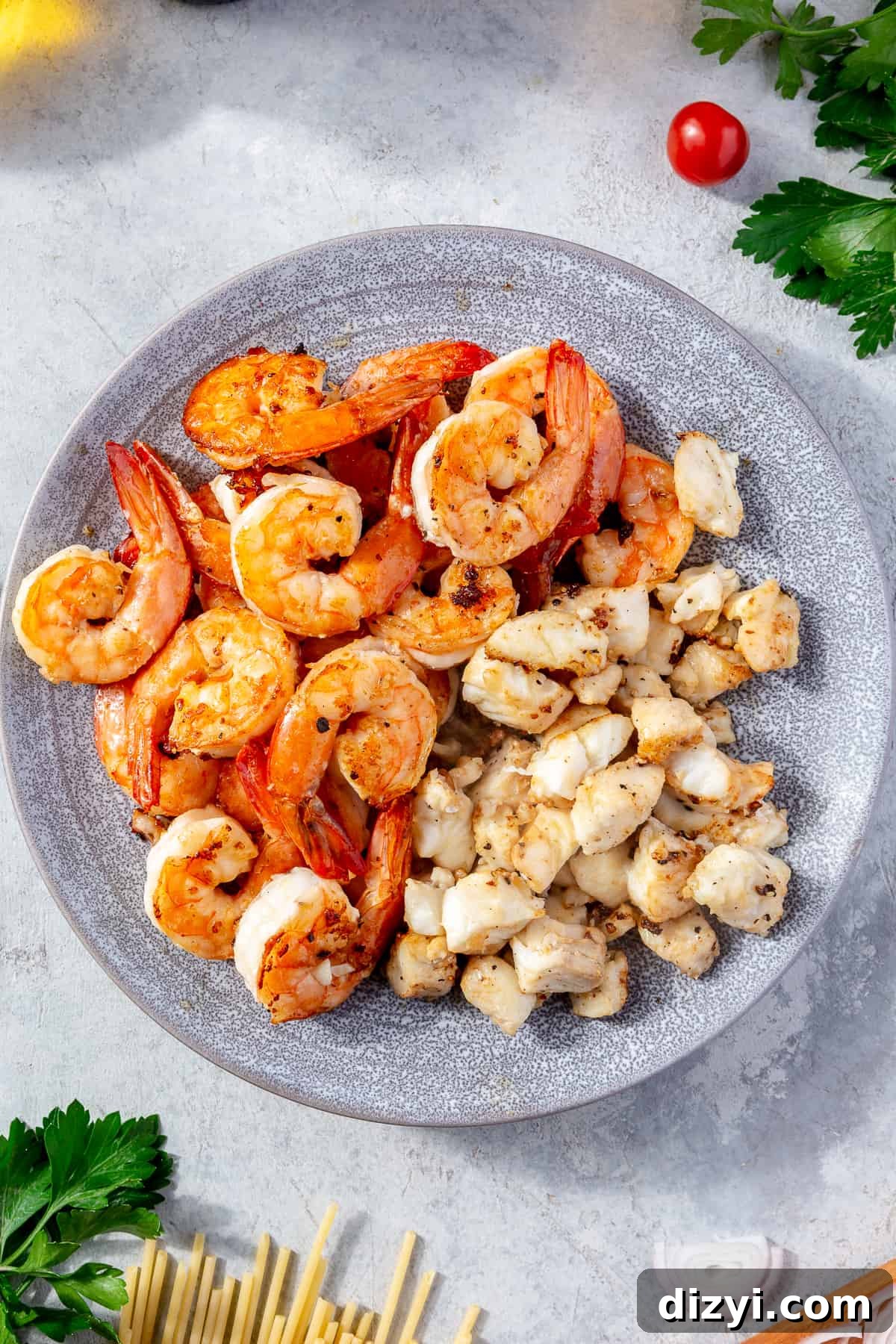 Cooked shrimp and halibut on a light blue plate.