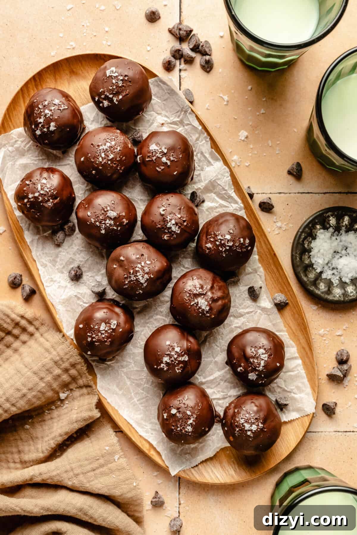 Thin Mint Energy Bites on a large platter. glasses of milk around. Chocolate chips and flaky salt scattered around.